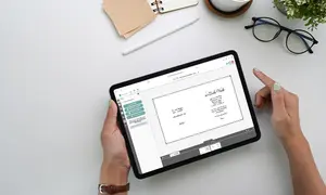 Das Design der Einladungskarte oder Dankeskarte wird am Tablet überprüft